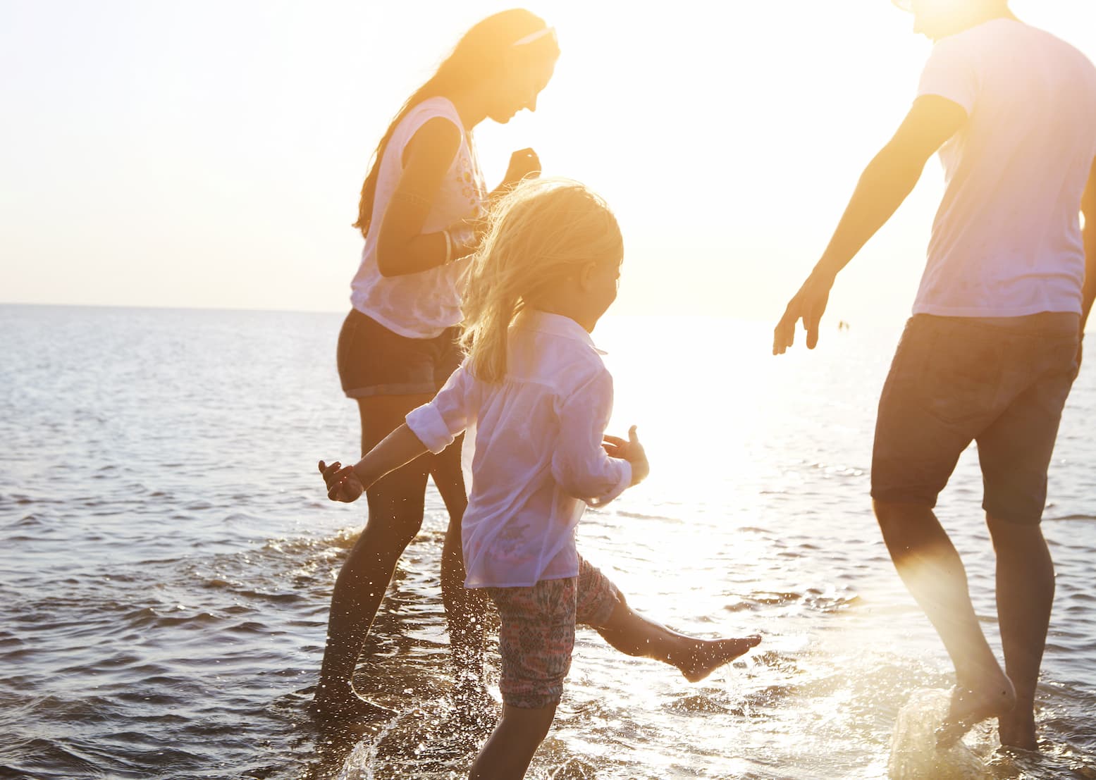 family on the beach playing in the water