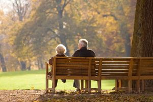 Older couple sitting on park bench.