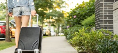 Woman walking away with suitcase