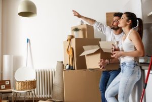 Couple standing in house with moving boxes