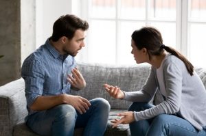 Man and woman sitting on a couch talking