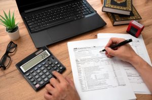 Tax papers, a calculator and a laptop on a table 