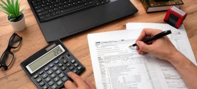 Tax papers, a calculator and a laptop on a table