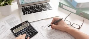 Desk with a computer, calculator and tax documents