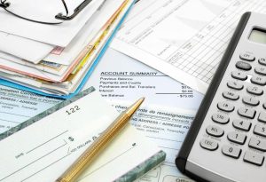 Bills, checkbook and a calculator on a table